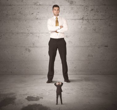 Büyük bir iş adamı küçük bir iş arkadaşına bakıyor.