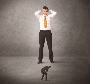 Büyük iş adamı küçük işçilere bakıyor.