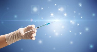 Kadın doktor elinde şırınga tutuyor.