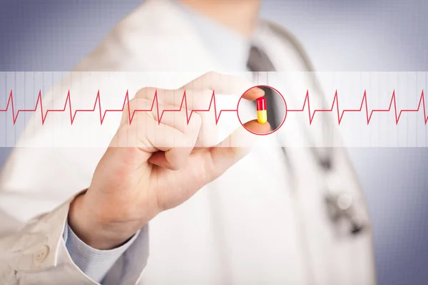 En läkare som håller i ett hjärtpiller — Stockfoto