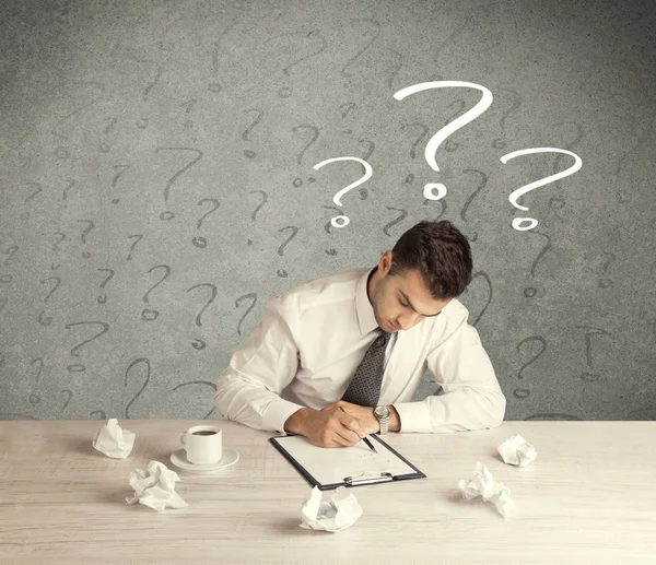 İş adamı soru işaretiyle masada.