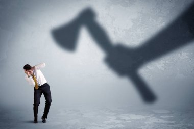 İşadamı bir balta kavramı tutan bir büyük gölge el korkuyor