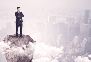 Kayanın üzerinde duran kazanan iş kişi