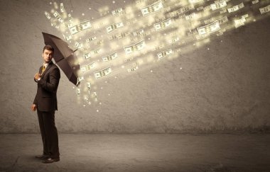 İş adamı dolar yağmuruna karşı şemsiye tutuyor