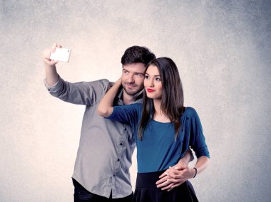 Mutlu çift temiz duvarlı selfie çekiyor.