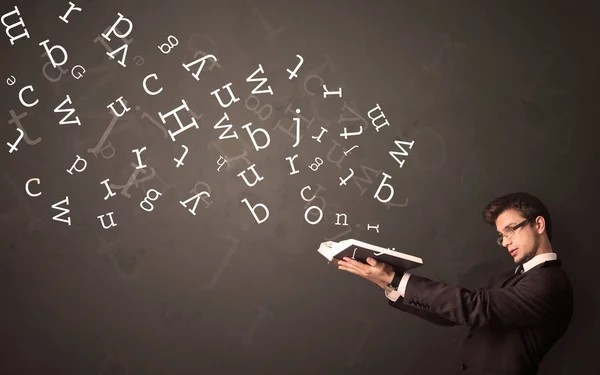 Young man holding book with letters — Stock Photo, Image