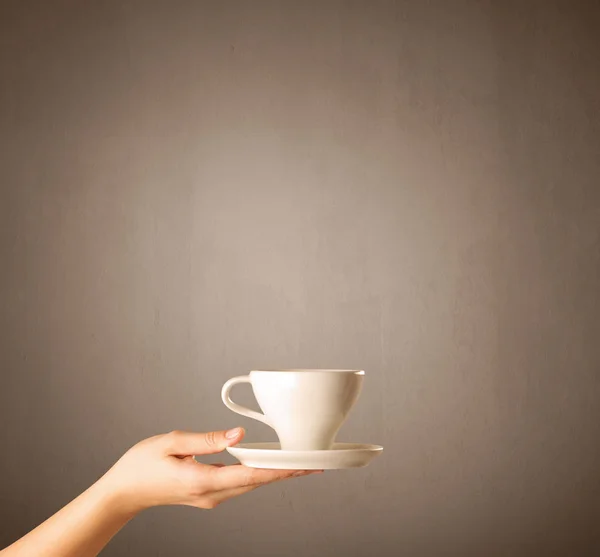 Vrouwelijke hand bedrijf koffie beker — Stockfoto