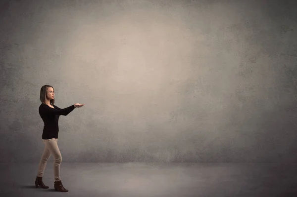 Woman standing  in front of a blank wall — Stock Photo, Image