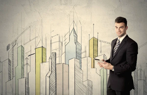 Businessman standing with drawn cityscape — Stock Photo, Image