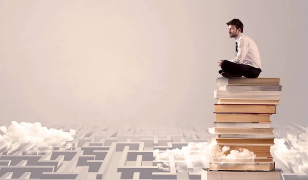 Empresário sentado em livros em labirintos — Fotografia de Stock