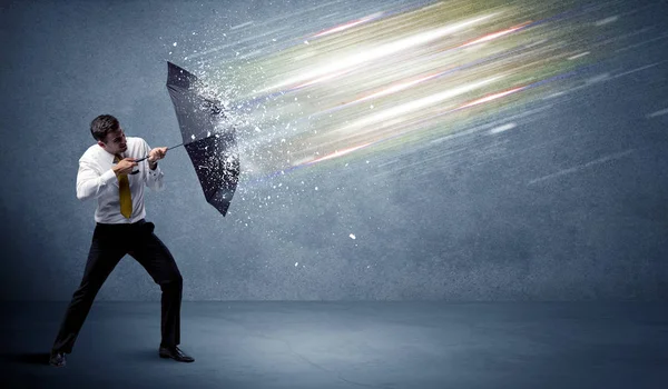 Homem de negócios defendendo feixes de luz com conceito guarda-chuva — Fotografia de Stock