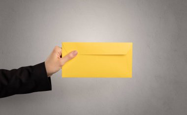 Zarf boş duvar arka plan ile tutan el