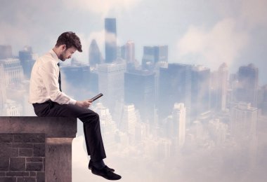 Yüksek bir binanın tepesinde oturan satıcı.