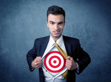 İş adamı göğsünde hedef işareti olan gömleğini yırtıyor.