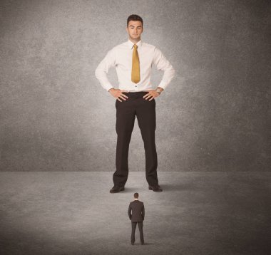 Büyük iş adamı küçük işçilere bakıyor.