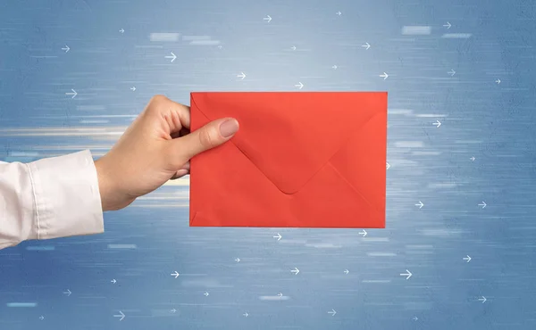 Hand met envelop met pijlen rond — Stockfoto