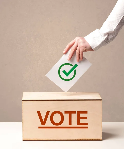 Fechar a mão masculina colocando voto em uma urna — Fotografia de Stock