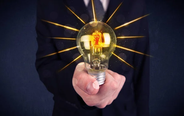Предприниматель, держащий электрическую лампочку — стоковое фото