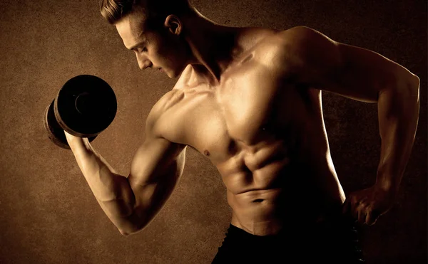 Kas formundaki vücut geliştirici sporcu ağırlık kaldırıyor 