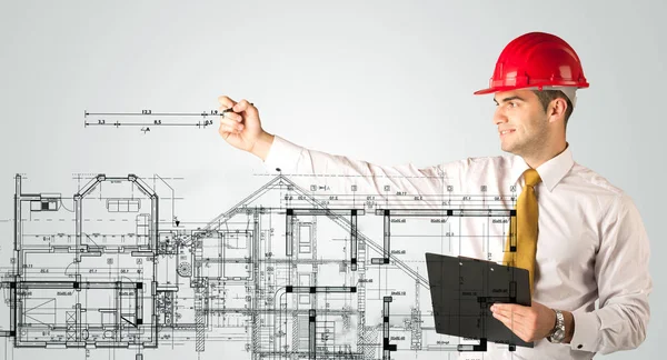 Genç bir mimar ev planı çiziyor.