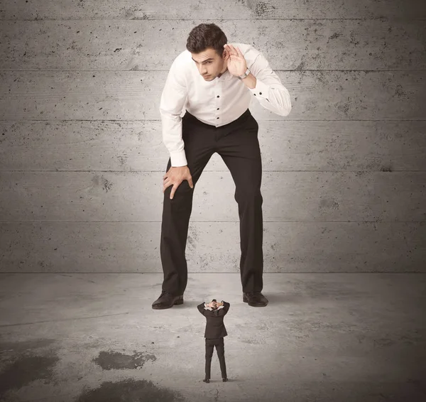 Büyük bir iş adamı küçük bir iş arkadaşına bakıyor.