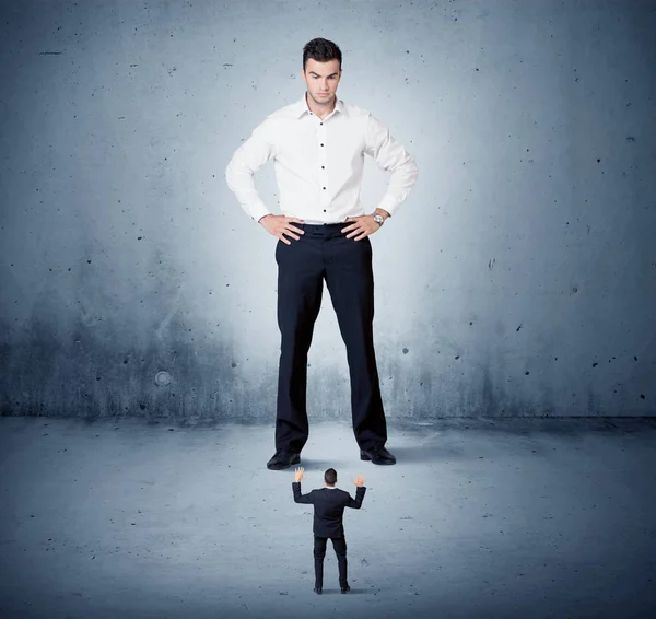 Öfkeli büyük iş adamı küçük adama lokma atıyor.