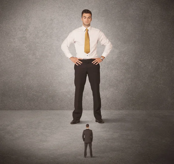 Büyük iş adamı küçük işçilere bakıyor.