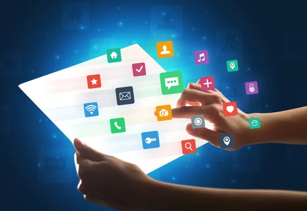 Mãos tocando um tablet tipo vidro com ícones coloridos — Fotografia de Stock