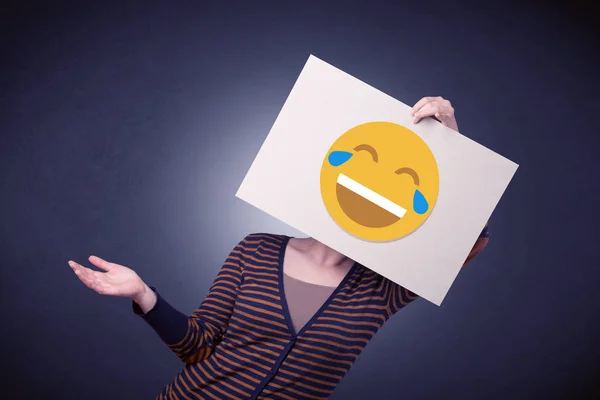Mujer sosteniendo papel con emoticono risueño —  Fotos de Stock
