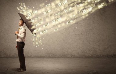 İş adamı dolar yağmuruna karşı şemsiye tutuyor