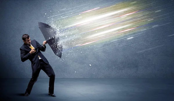 Hombre de negocios defendiendo haces de luz con concepto de paraguas — Foto de Stock