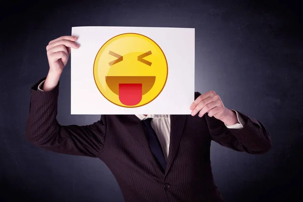 Empresario sosteniendo papel con emoticono —  Fotos de Stock