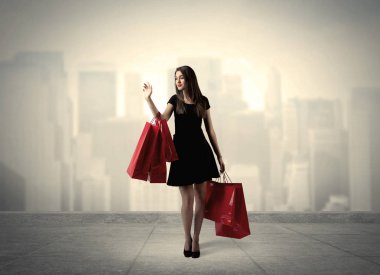 Kırmızı alışveriş çantalı zarif şehir kızı.