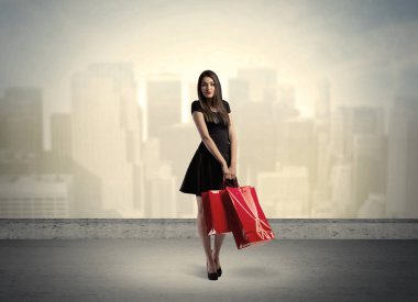 Alışveriş torbalarıyla duran şehir kadını.