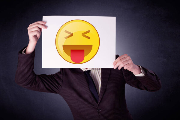 Businessman holding paper with emoticon 
