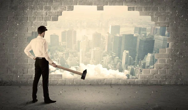 Affärsman slår vägg med hammare på stadsutsikt — Stockfoto