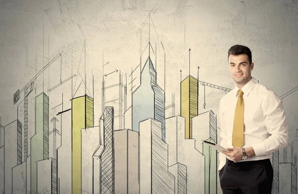 Businessman standing with drawn cityscape — Stock Photo, Image