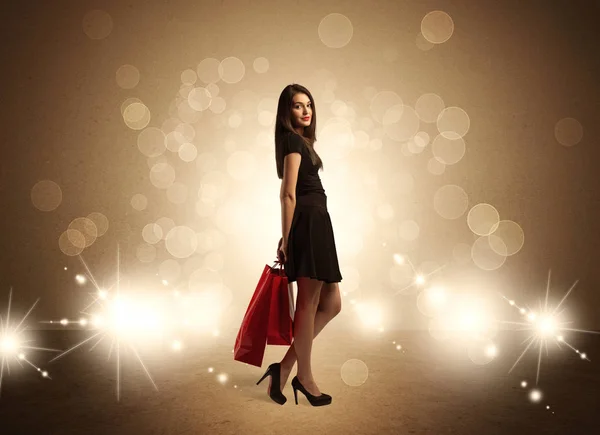 Shopping lady with bags in bright lights — Stock Photo, Image