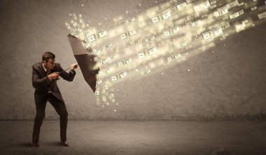 İş adamı dolar yağmuruna karşı şemsiye tutuyor