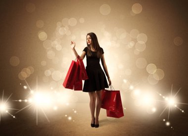 Parlak ışıklarda çantalı alışveriş yapan kadın.