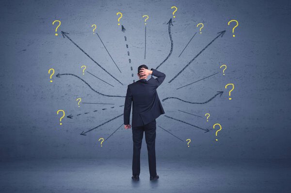 Бизнесмен, стоящий на переднем крае и знак вопроса знак conc
