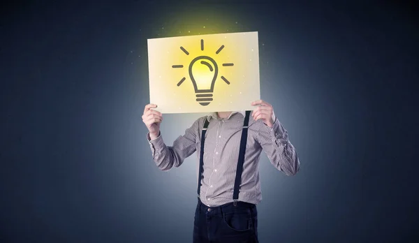 Empresário segurando papel com lâmpada — Fotografia de Stock