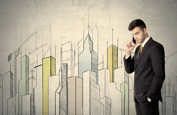 Businessman standing with drawn cityscape — Stock Photo, Image