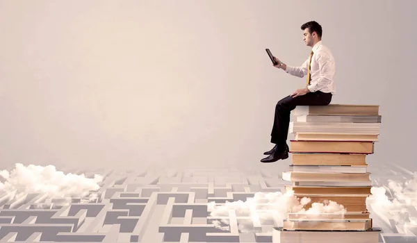 Man met tablet zittend op boeken — Stockfoto