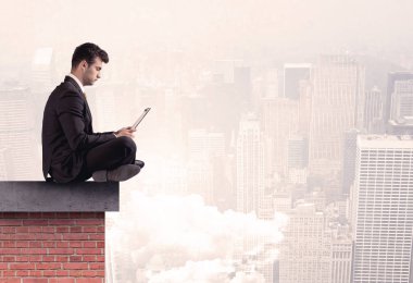 Şehirde çatıda oturan ofis çalışanı