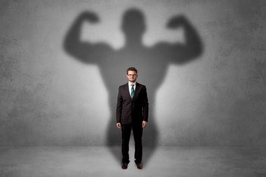 Businessman with muscular shade behind his back clipart