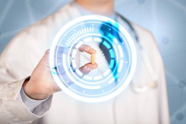 Erkek doktor elinde parlak halkaları olan bir hap tutuyor.