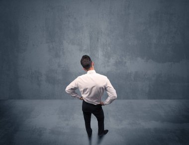 Şehir duvarının önünde duran iş adamı