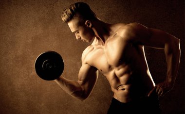 Kas formundaki vücut geliştirici sporcu ağırlık kaldırıyor 