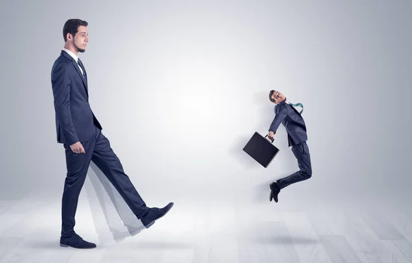 Gigante empresário chutando para fora pequeno empresário — Fotografia de Stock